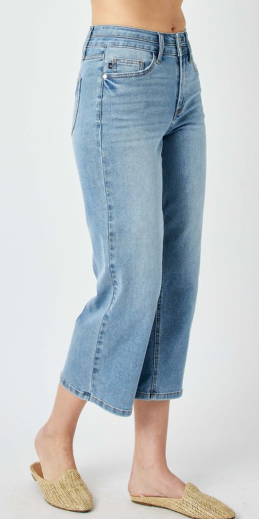 Crop blue jeans with a high waist, medium blue in color two buttons to close at the waistline.