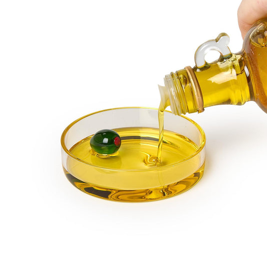 Olive oil pours into the Dipping / Tidbit Dish with Olive, featuring a green olive with red pimento. Available in multiple sizes.