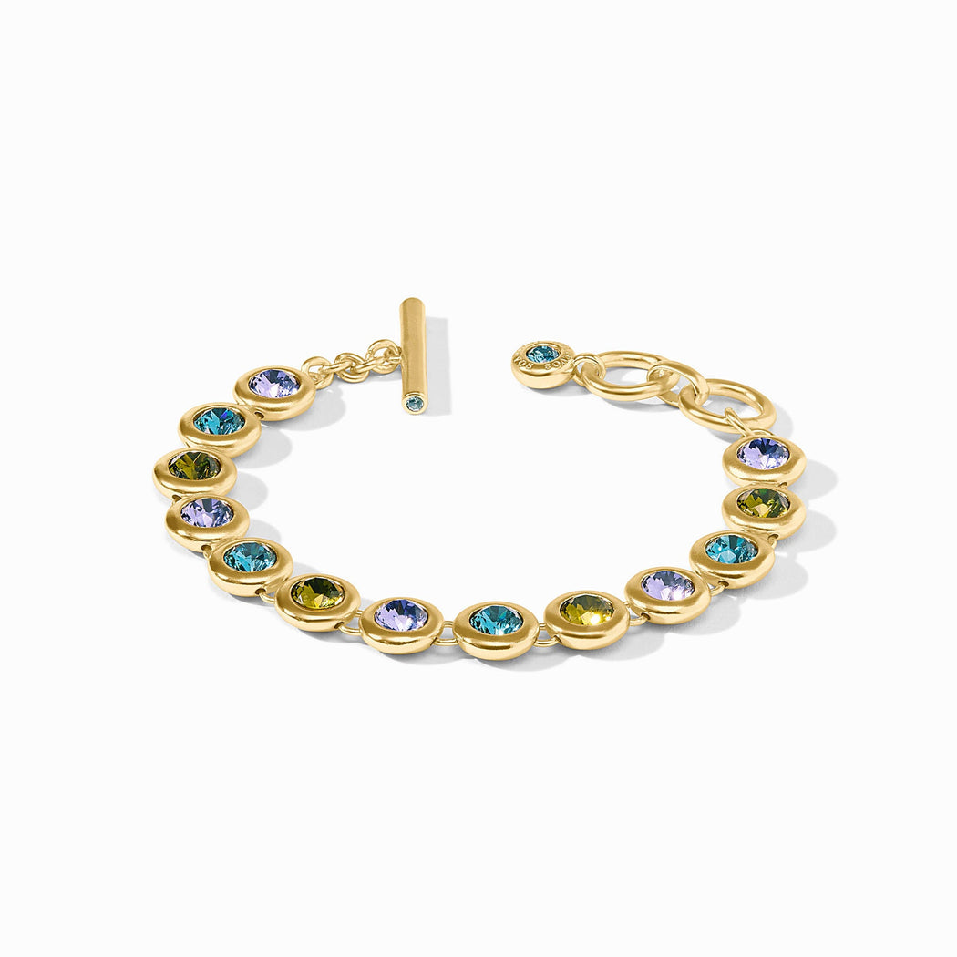 The Rainbow Tennis Bracelet | Blue Twilight: round bezel-set multicolored gems, 24K gold plate, toggle clasp, adjustable sizes.