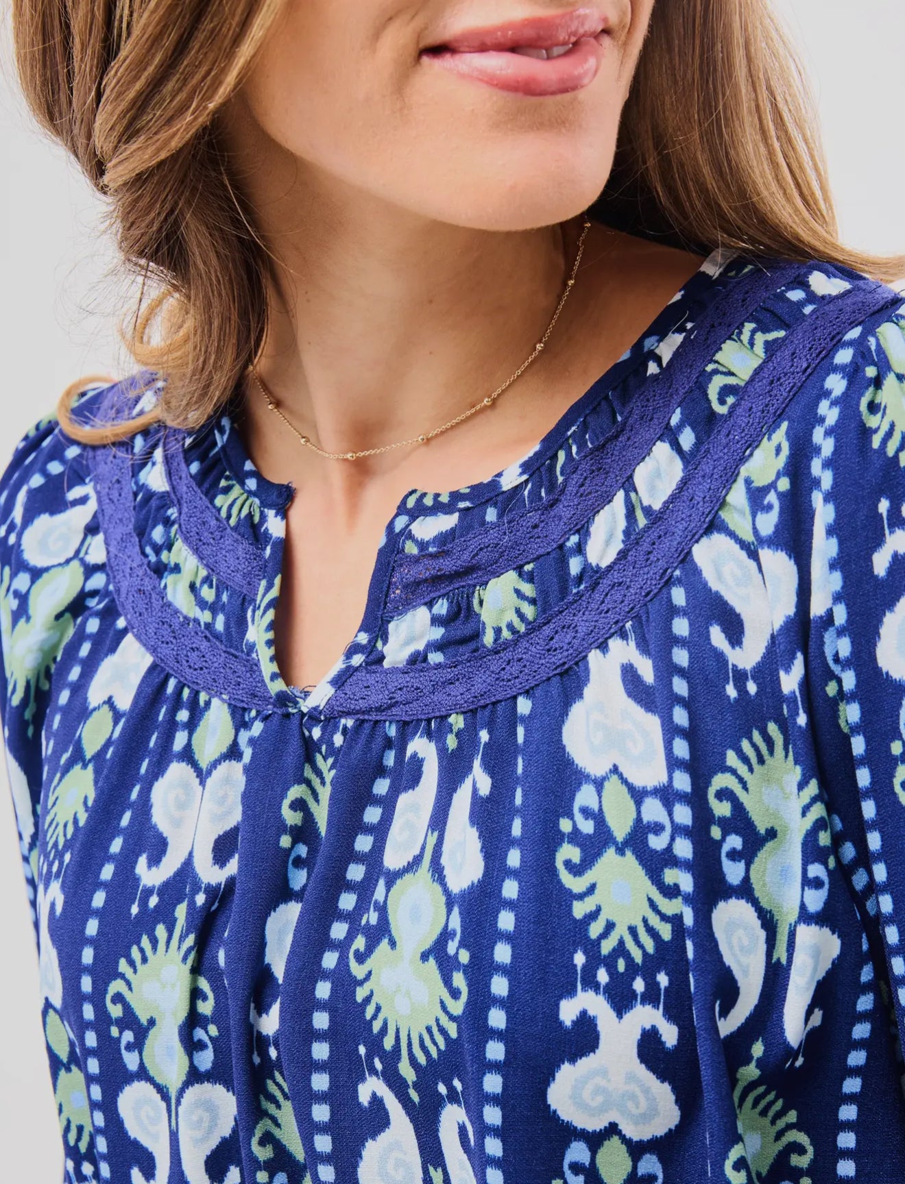 Janelle Top Ikat Stripe: blue blouse with green and white patterns, notched neckline. Available in sizes XS–XL.