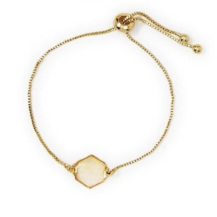 Gold bracelet with adjustable sliding clasp and hexagonal white rhinestone centerpiece. Available in one size.