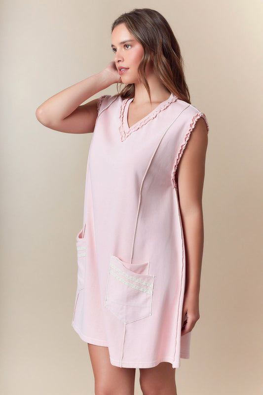 Gillian Pink Terry Dress: loose, sleeveless, light pink, ruffled trim, two front pockets. Available in sizes XS–XL.