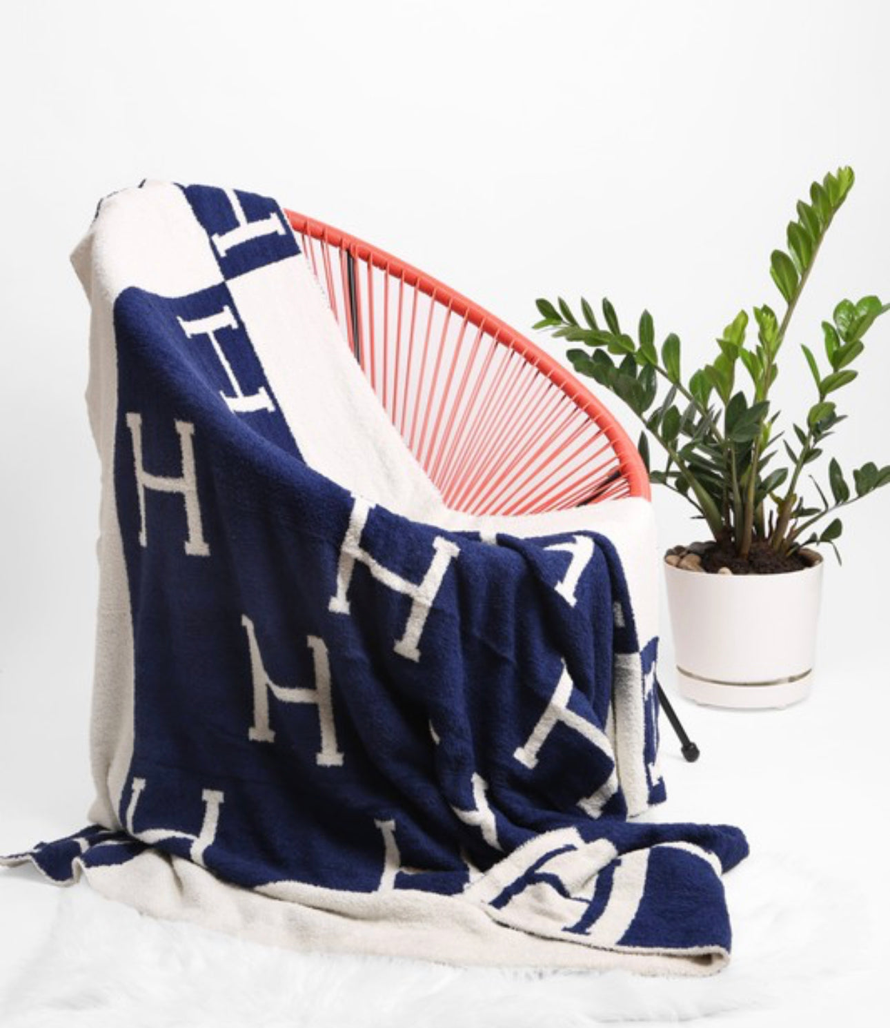 Navy blue and cream 50" x 60" blanket with large “H”s pattern. Available in 50" x 60".