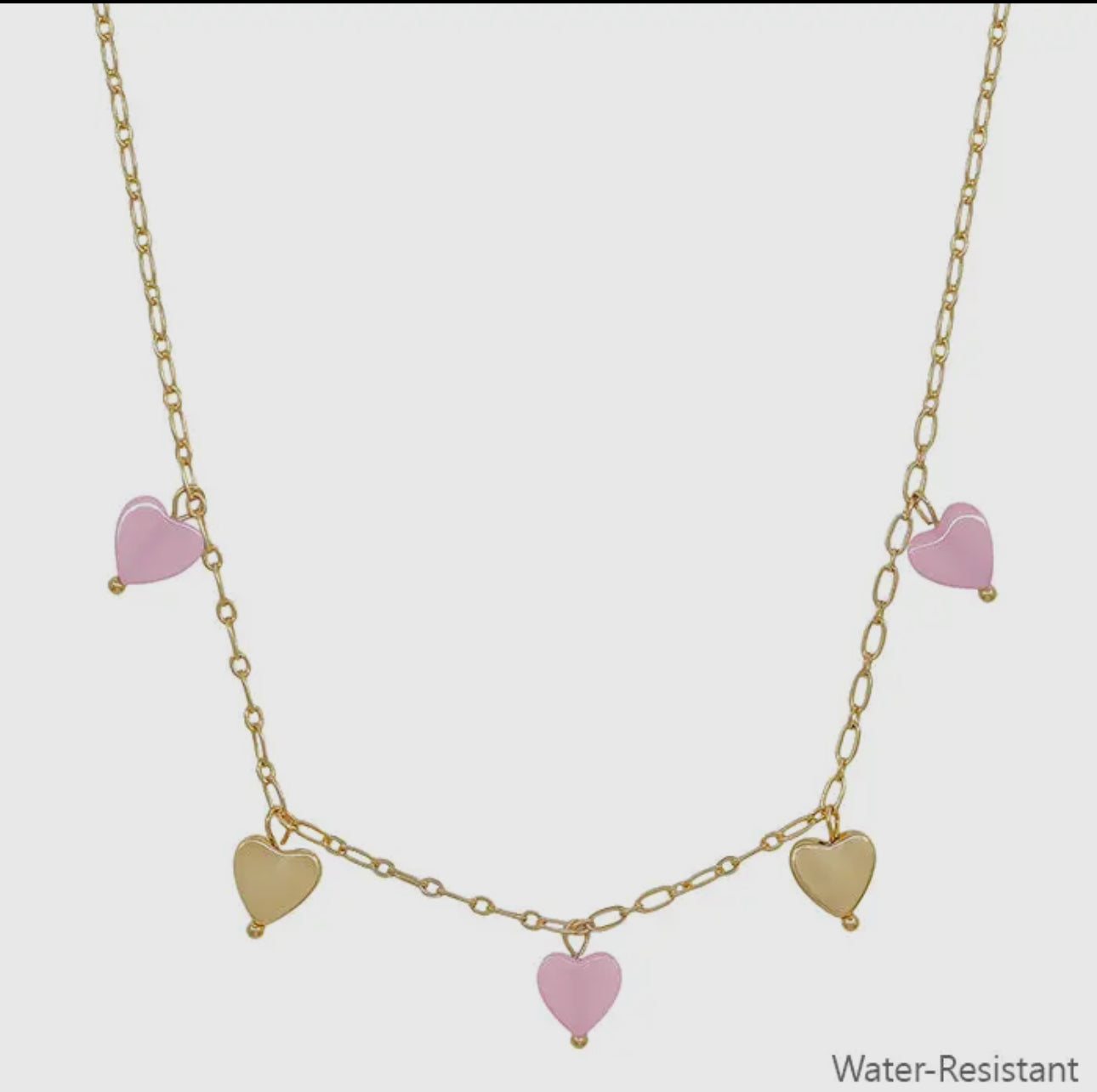 Gold chain necklace with three pink and two gold heart charms; water resistant. Available in multiple sizes.
