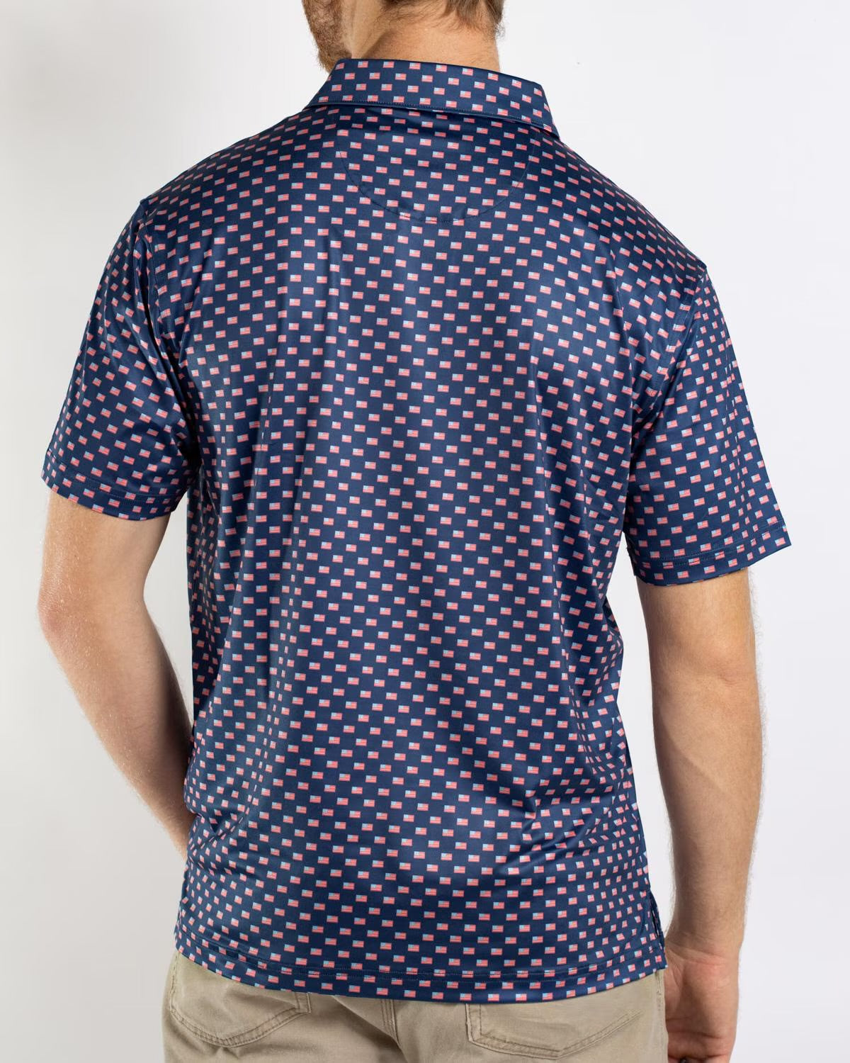 Men’s Americana Performance Polo in navy blue with pink and white square pattern and short sleeves; available in sizes S-XXL.