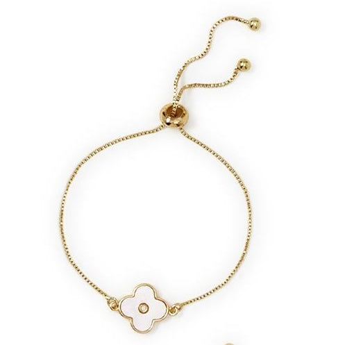 Gold chain bracelet with white four-petal flower charm, two gold bead accents. Adjustable size.