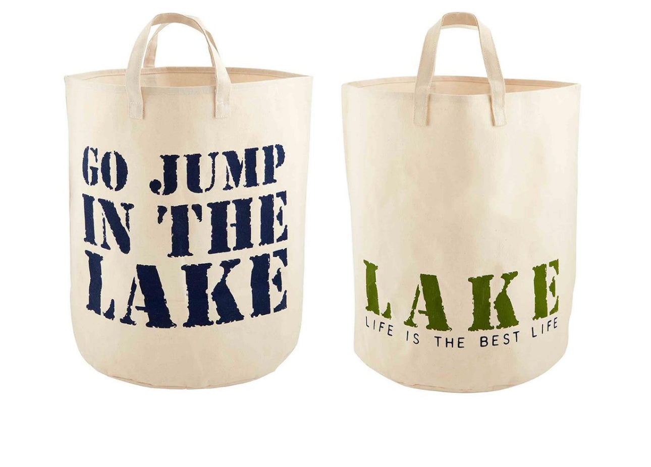 Set of two beige canvas totes with handles, 20" x 26". One says “GO JUMP IN THE LAKE,” the other “LAKE LIFE IS THE BEST LIFE.”.