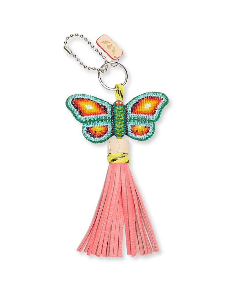Consuela Clay Butterfly Charm keyring with hand-beaded colorful pattern, pink leather tassel, metallic ring. Size info not shown.
