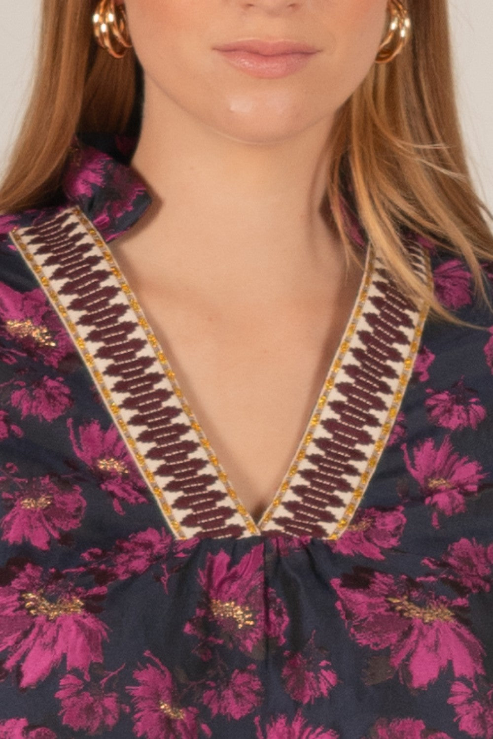 Floral Jacquard 3/4 Sleeve Dress with Contrast Collar. Dark floral dress with pink and gold flowers, decorative stitching in maroon, white, and gold on the V-neckline. Available sizes: S, M, L.