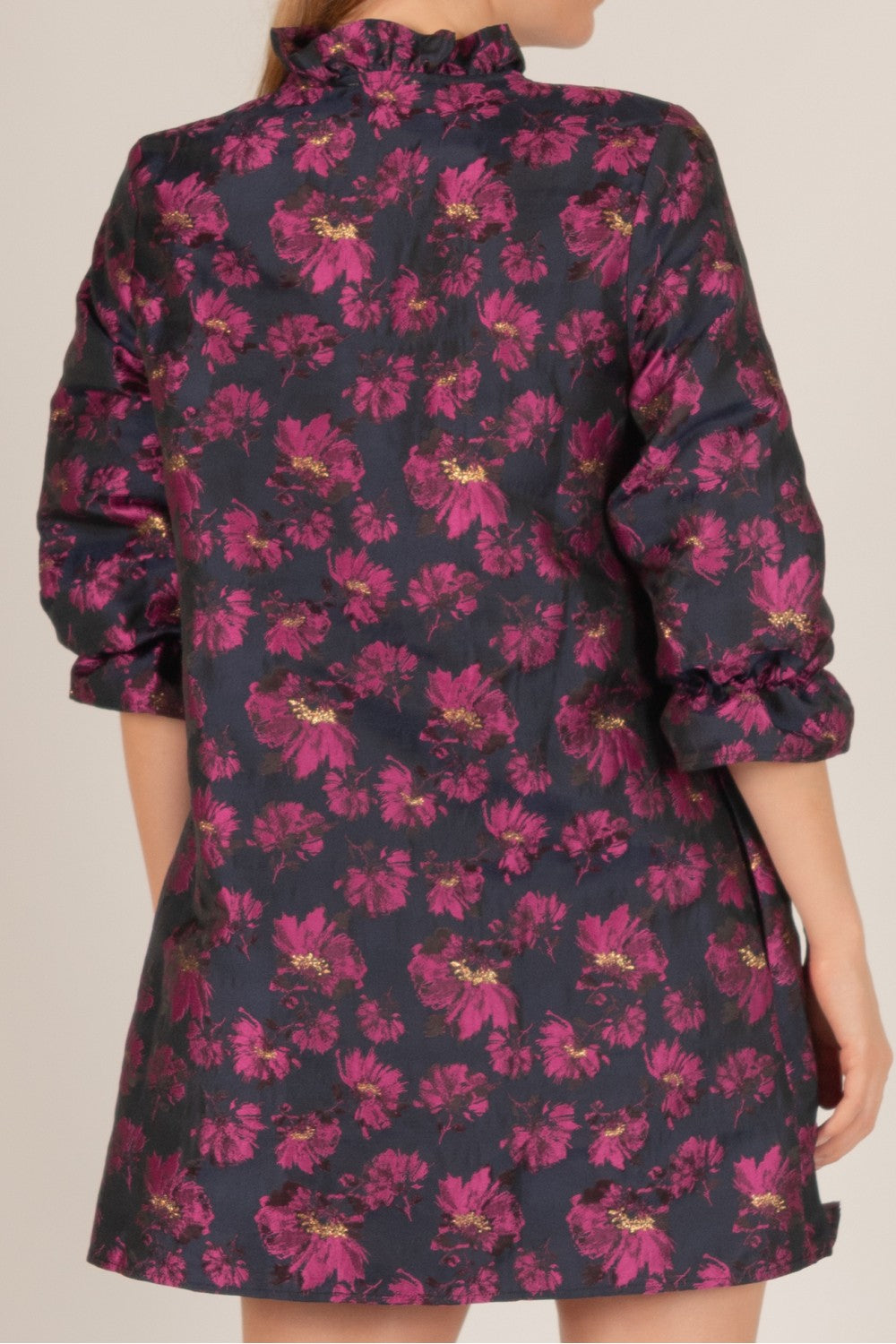 Floral Jacquard 3/4 Sleeve Dress featuring a bold floral pattern in shades of magenta and gold on a black background, with a high neckline and ruffled details. Ends above the knee. Available sizes: XS, S, M, L, XL.