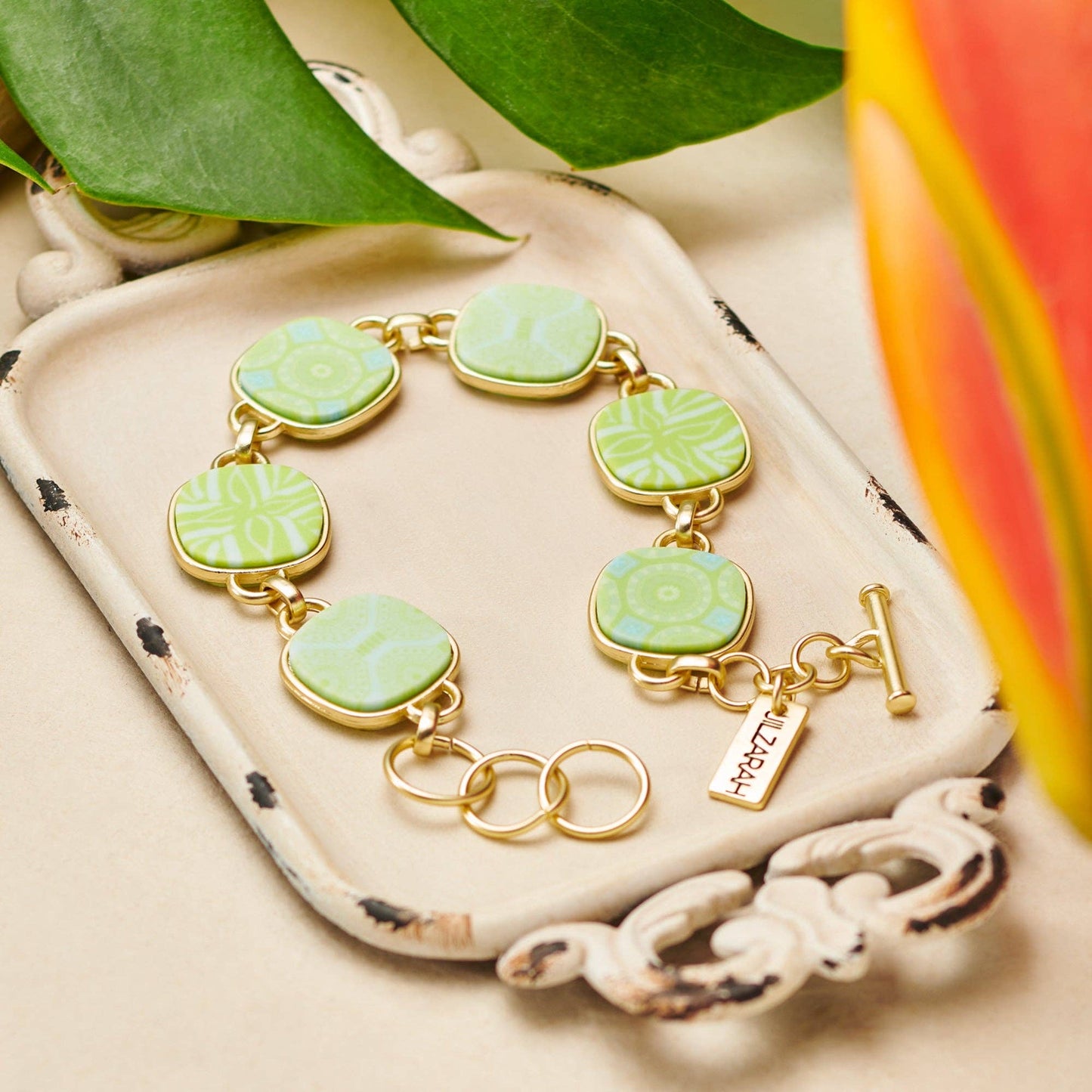 Palm Beach Reversible Coin Bracelet with patterned square links connected by gold loops. Includes a small rectangular charm near the clasp. Available in one size: adjustable fit.