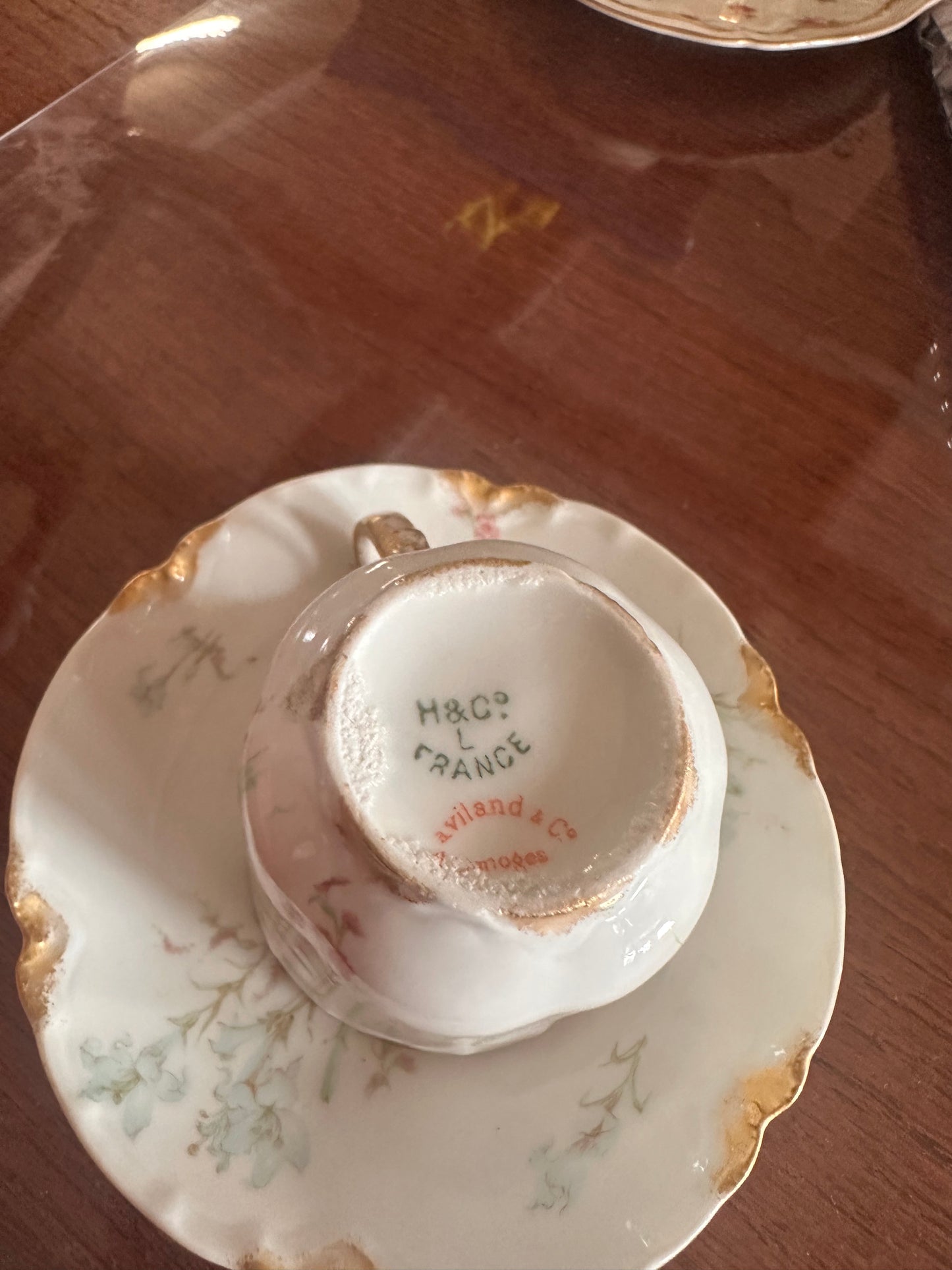Antique hand painted porcelain demitasse cup with gold trim and floral design, showing H&C, Haviland & Co. France marks. Size: demitasse.
