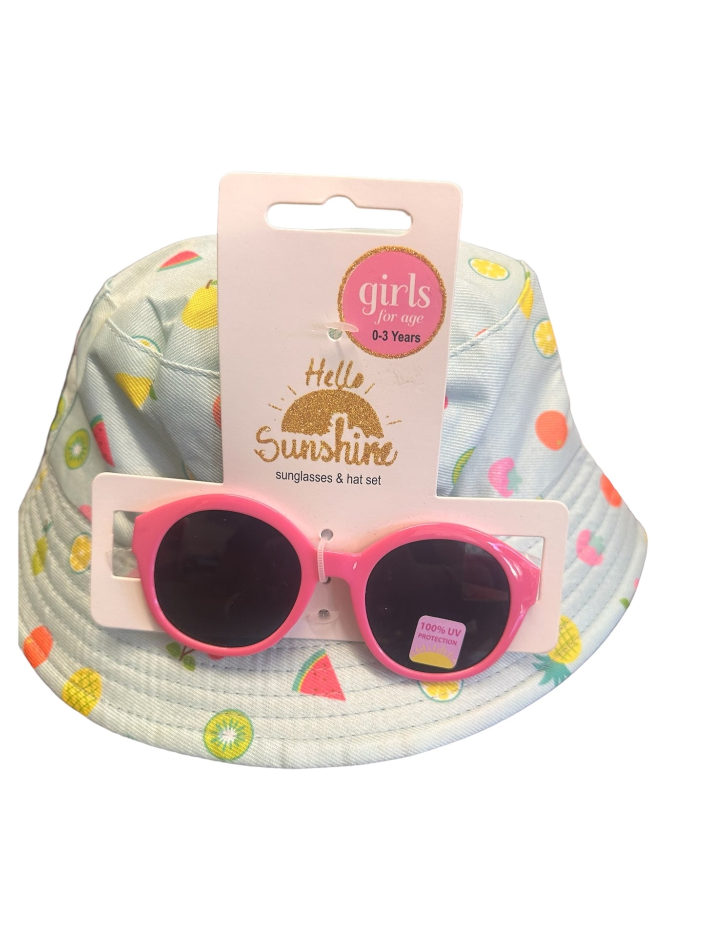 A stylish and adorable set for girls aged 0-3 years, featuring a light blue bucket hat with colorful fruit patterns and pink sunglasses with dark lenses. Tag: "Hello Sunshine - Kids Sunnies & Hat Sets" with UV400 protection. Sizes: 0-12 months, 12-24 months, 2-3 years.