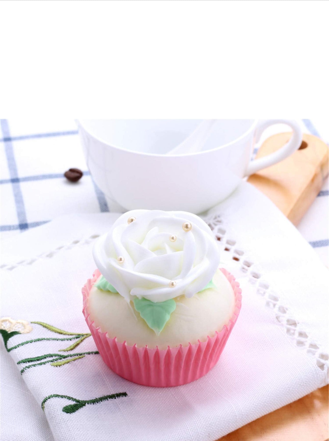 Faux cupcake with white rose-shaped frosting, gold pearls, and pink wrapper. Available in mini, standard, and large sizes.