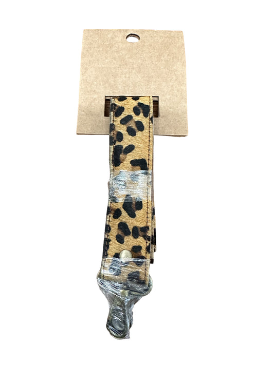 Folded leopard print guitar strap with metal hardware, partially wrapped in plastic. Available sizes: S, M, L.