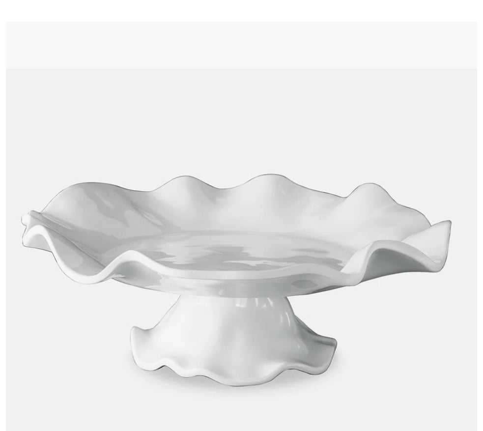 Vida Havanna Pedestal Cake Plate: White ceramic stand with wavy, scalloped edge and glossy finish. Shatter-resistant melamine. Sizes: 10", 12".