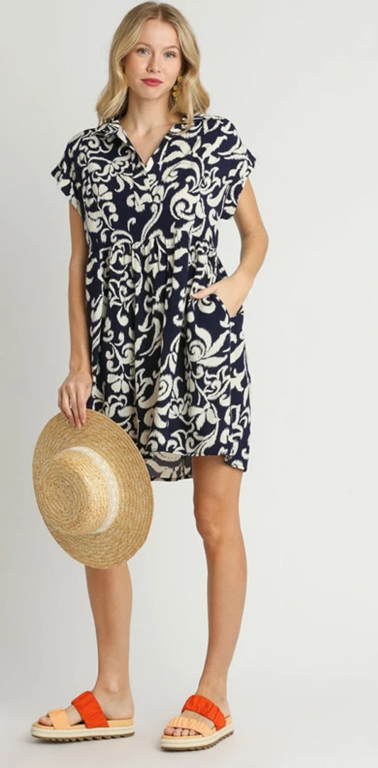 This navy blue and white pattern strolling dress is 100% rayon with a collar and short sleeve
