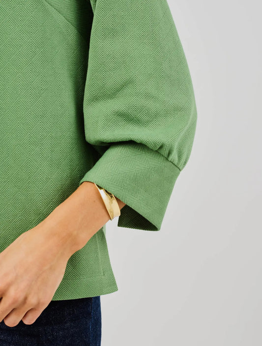 Jocelyn Green Top with textured fabric and loose sleeves. Available in sizes XS–XL.