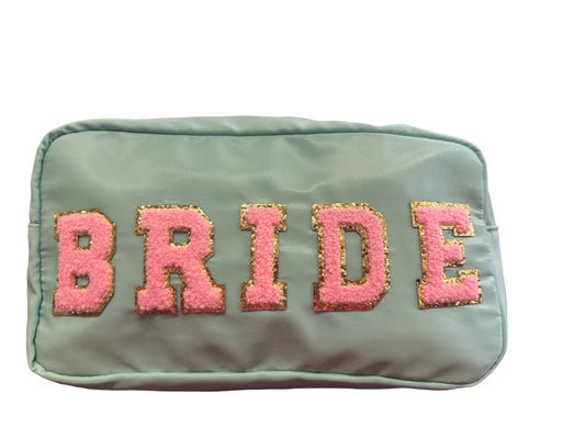 Broad cosmetic bag is mint green with rays lettering that spells bride and soft pink trimmed in gold it is 12 x 6