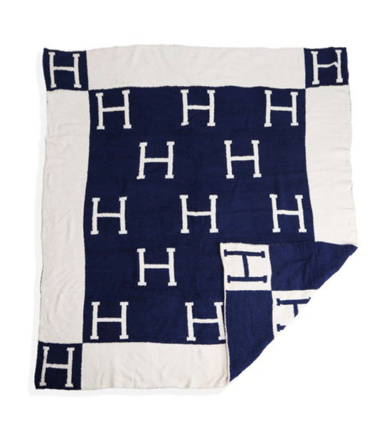 Reversible navy and white blanket, grid "H" pattern, soft poly microfiber, 50"x60", navy border, white corners.