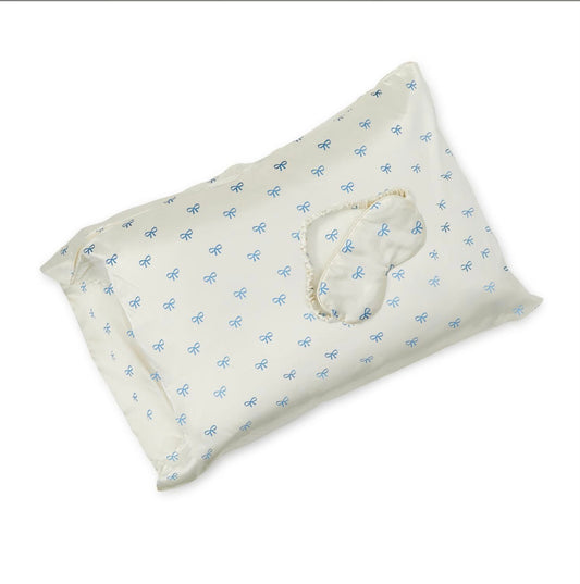 White satin pillowcase and blue-patterned eye mask with blue bows. Set available in standard and king sizes.