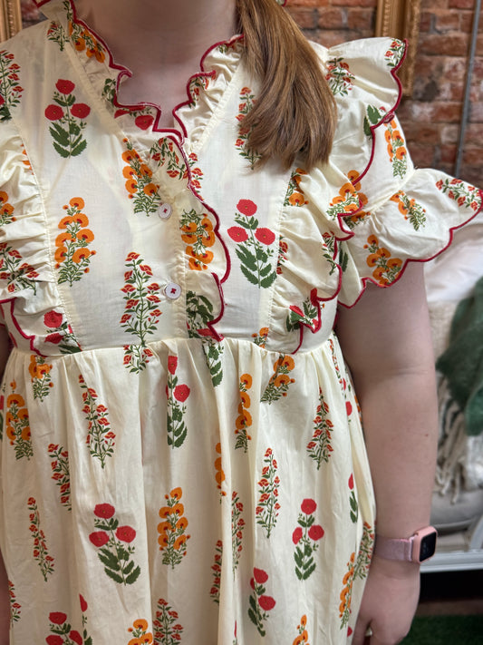 Butter Meadow Dress: cream floral, red edging, multicolor ruffled sleeves. Available in XS-XL.