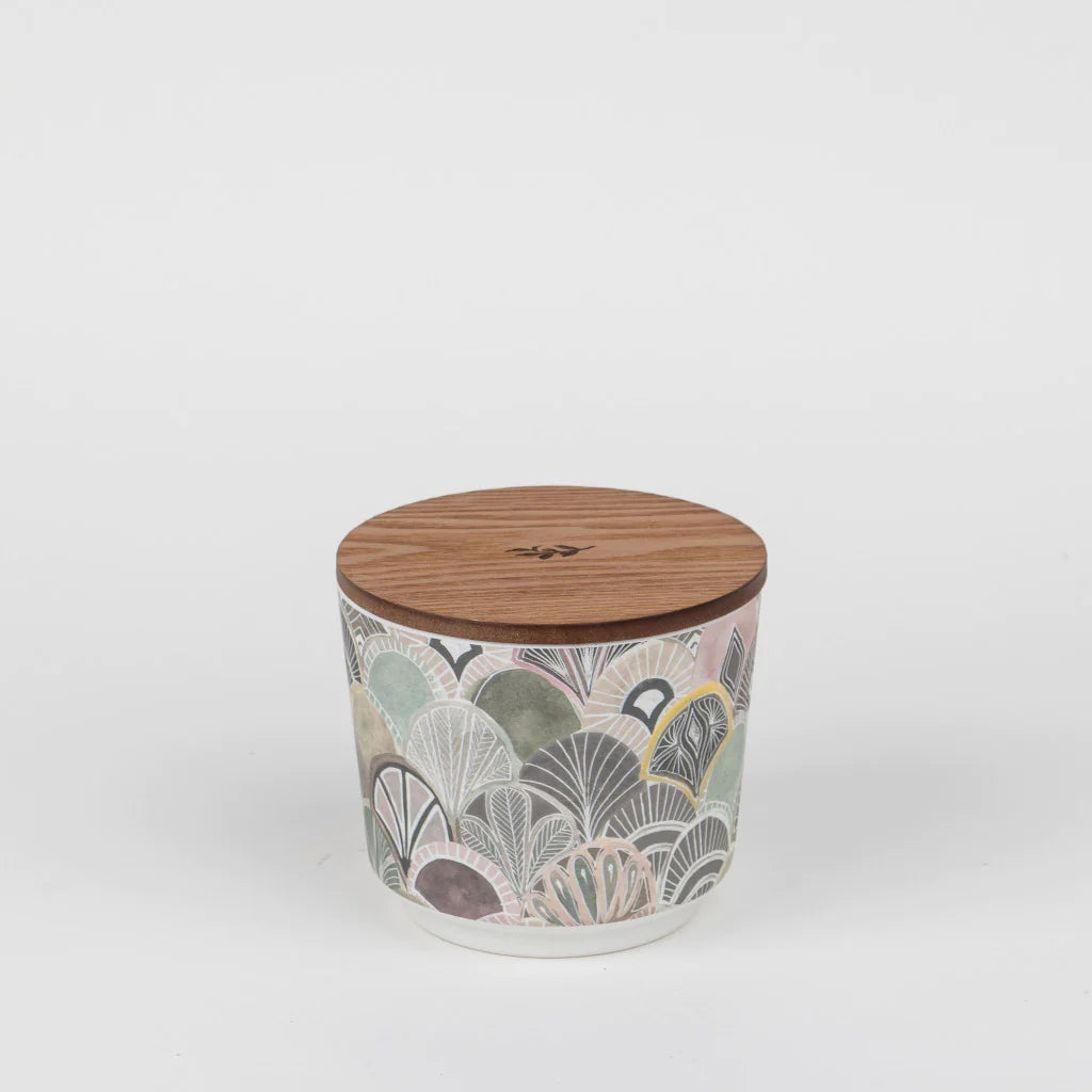 The Haven 3-Wick Candle GLG925489 in a green, grey, cream, and purple art deco ceramic holder with wooden logo lid. Sizes vary.