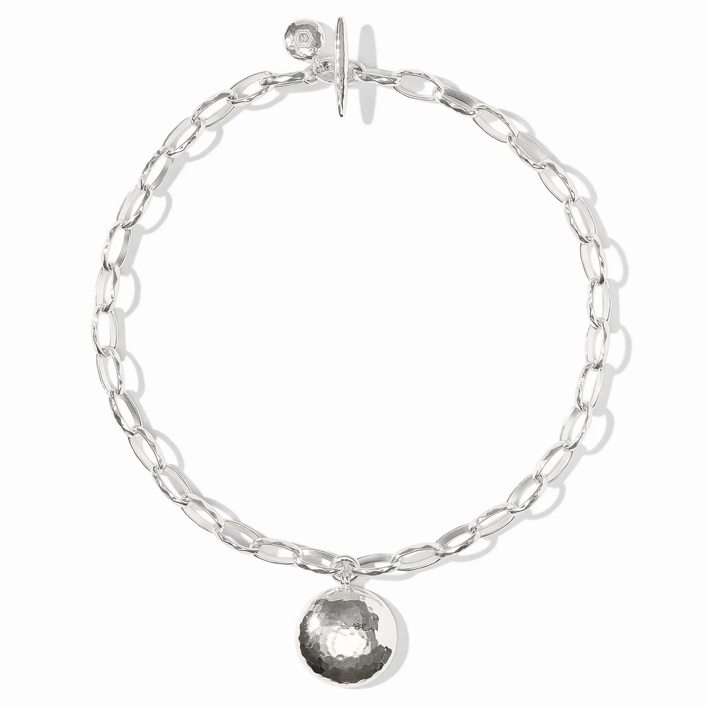 The Solara Necklace Silver: elongated oval chain, hammered starburst medallion, toggle clasp. Available in 16", 18", 20".