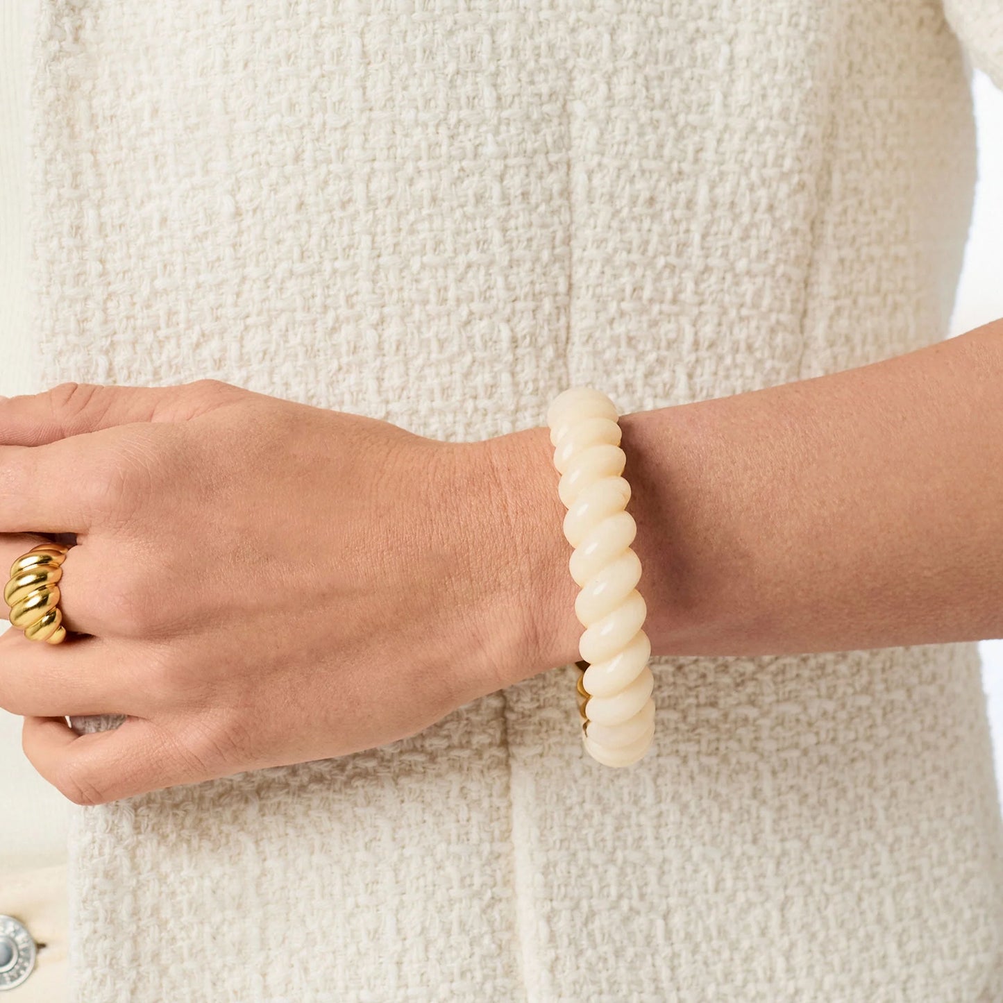 Ravello Statement Bangle: cream-colored, twisted 24K gold-plated bracelet with an ivory glass gemstone. Available in small, medium, and large sizes.