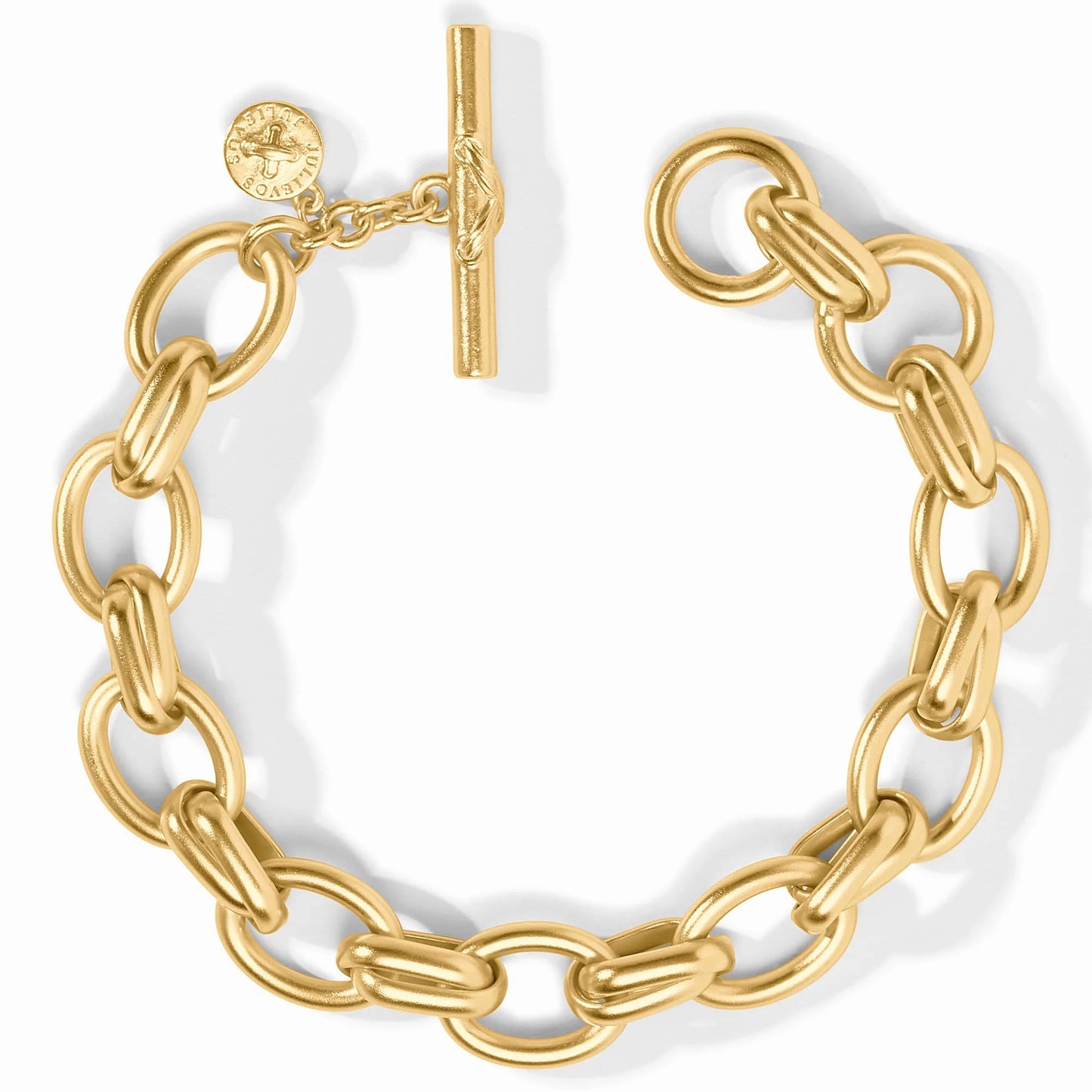The Essex Link Bracelet by Julie Vos features large oval links with a chunky 24K gold-plated finish, secured with a toggle clasp and an engraved round charm. Available in multiple sizes.