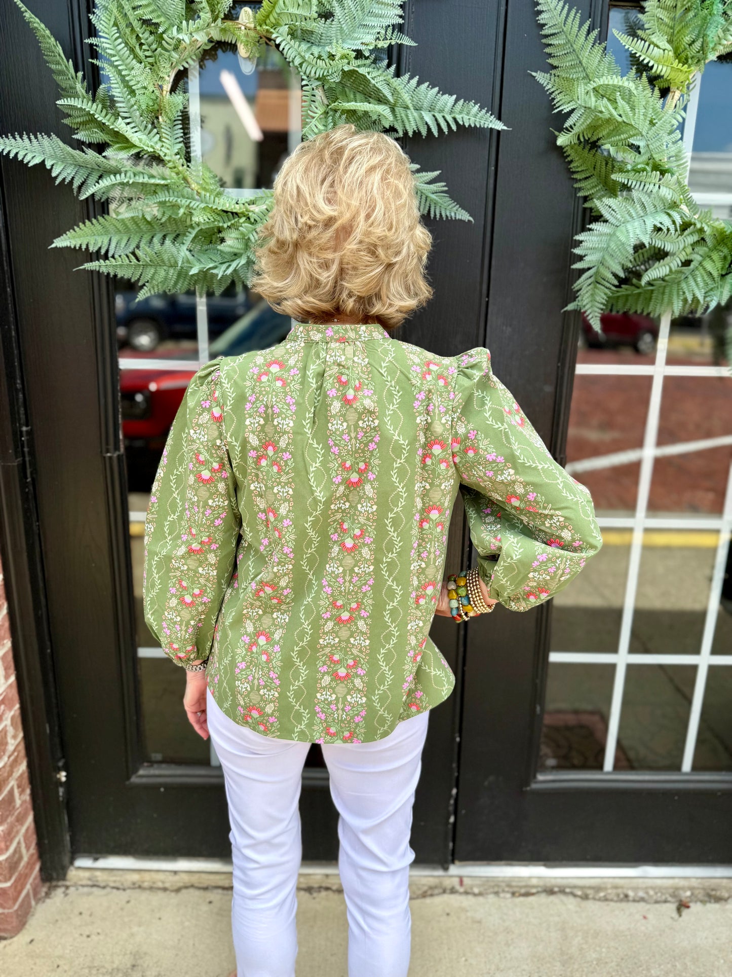 Lia Top: green floral blouse, 3/4 puff sleeves, quarter button collar, pink accents. Sizes: XS–XL.