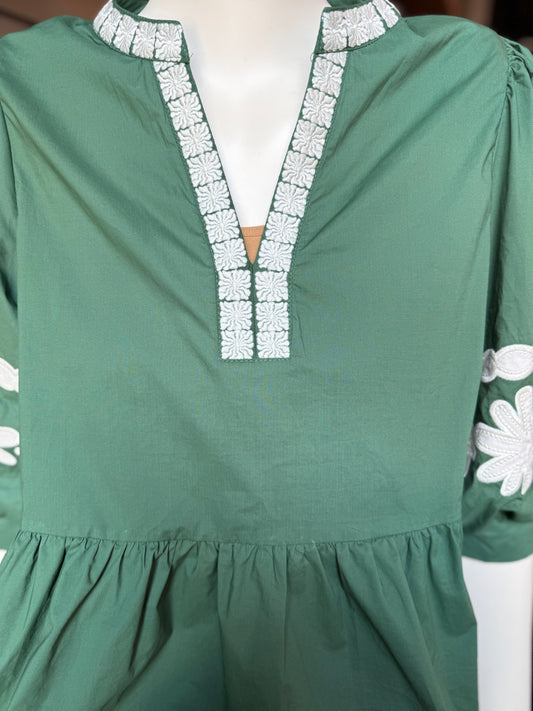 Green top with white floral embroidery, V-slit neckline, gathered waist, bubble sleeves. Available in sizes XS-XL.