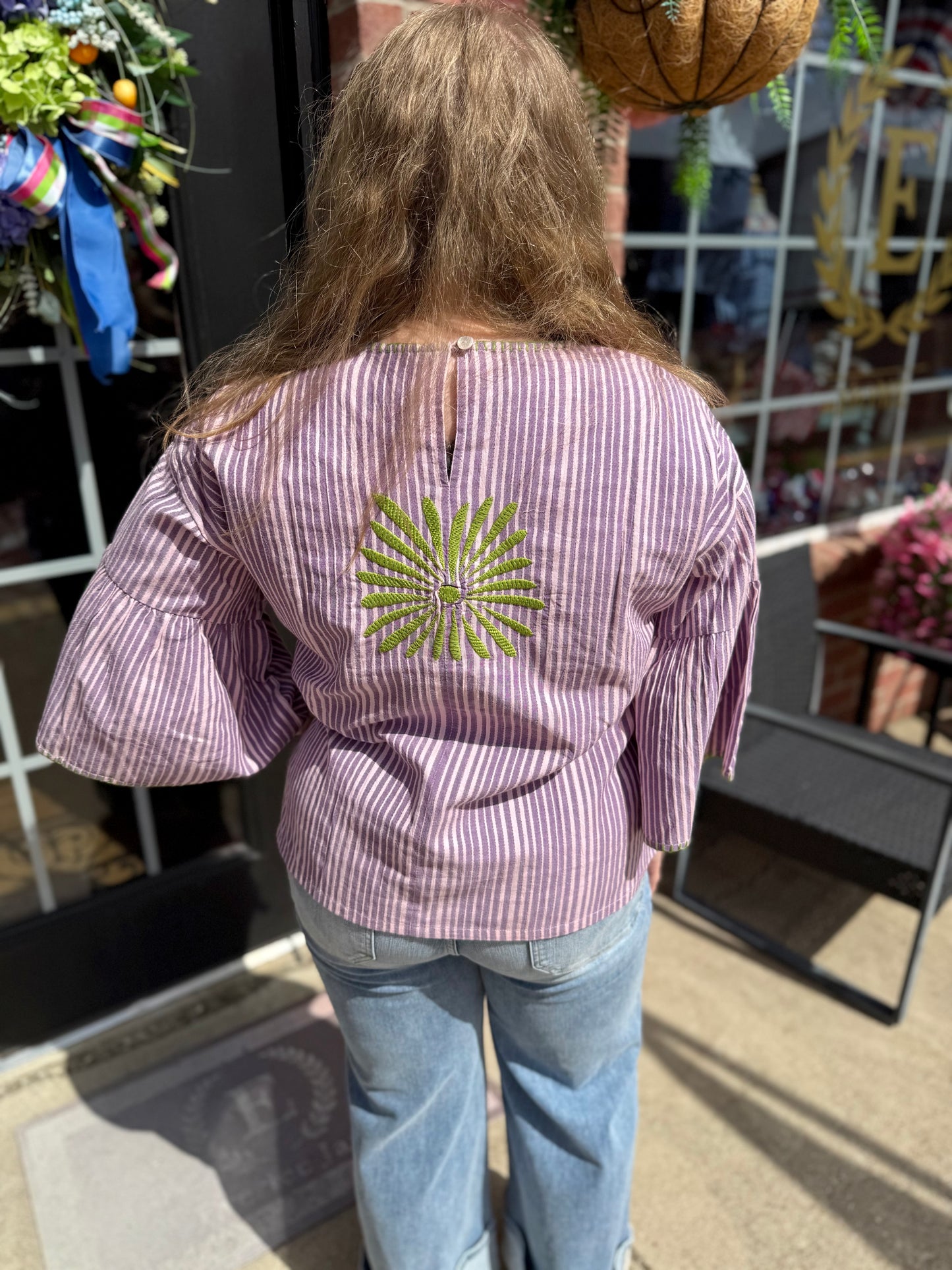 Purple Elena Blouse with wide sleeves and green geometric embroidery on back. Available in sizes XS-XL.