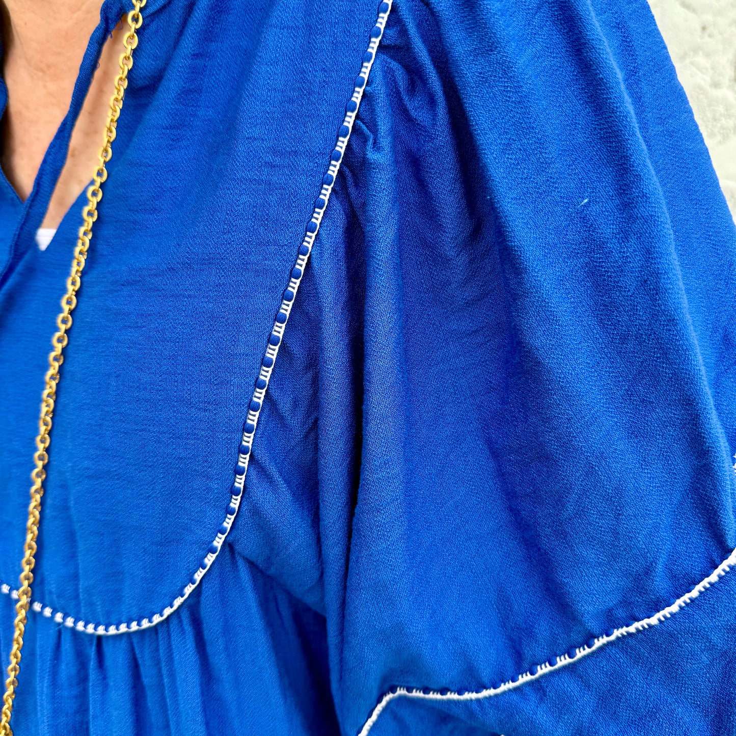 Blue Belle Lace Trim Blouse with white lace on ruffled sleeve and bodice. Available in sizes XS–XL.