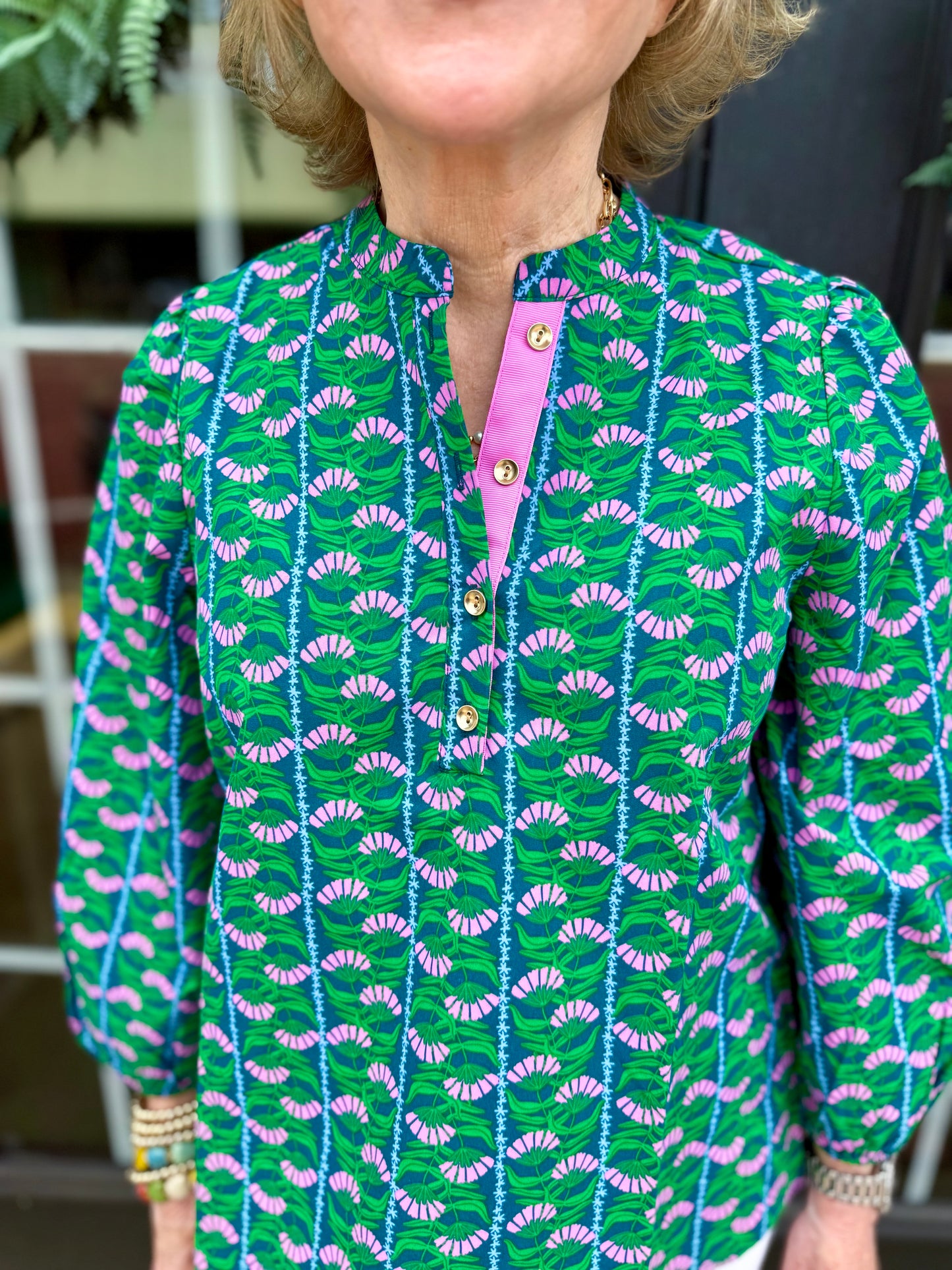 Lia Top: green blouse with blue, purple, white fan patterns, 3/4 puff sleeves, pink quarter button collar. Sizes XS–XL.