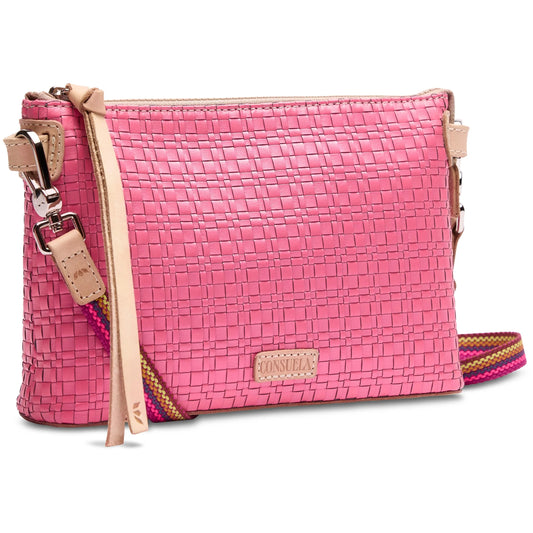Woven pink crossbody bag with beige leather trim, colorful adjustable strap, front beige "Consuela" leather tag, and decorative leather tassel. Available sizes: One Size.