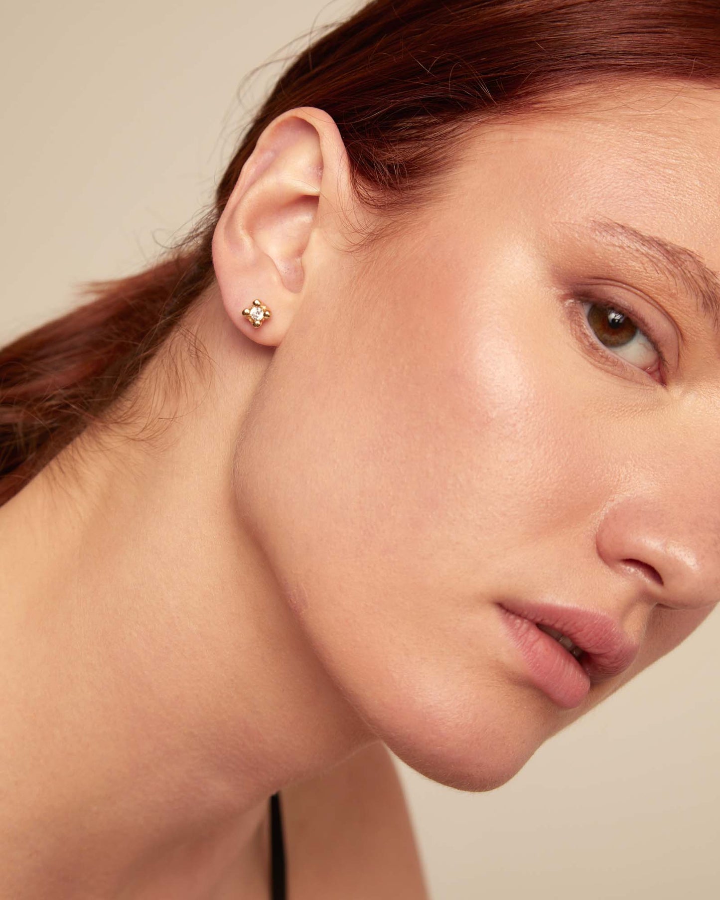 Small floral stud earrings crafted from 18K gold-plated metal with sparkling white cubic zirconia, available in multiple sizes.