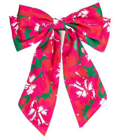The Holiday Bows feature a large, vibrant bow with a floral pattern in bright pink and green hues, accented with white. It has long, wide tails that showcase the colorful design. Available sizes: Small, Medium, Large.