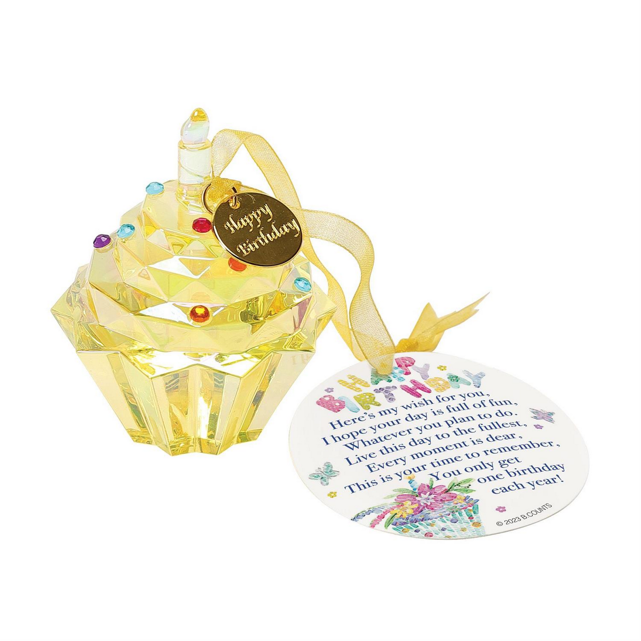The Happy Birthday Cupcake Ornament is a decorative yellow crystal figurine shaped like a cupcake, featuring a candle and "Happy Birthday" tag. Part of Enesco's Facet Collection, it includes colorful gem accents. It comes attached to a circular card with illustrations of balloons and confetti. Suitable for gifting. Size: 3 inches tall.