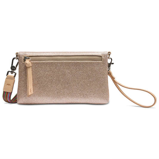 The Emery Uptown Crossbody is a glittery gold clutch with a wristlet strap, card holder slots, and a decorative zipper pocket. It includes a detachable multicolored shoulder strap for crossbody use. Available sizes: One Size.