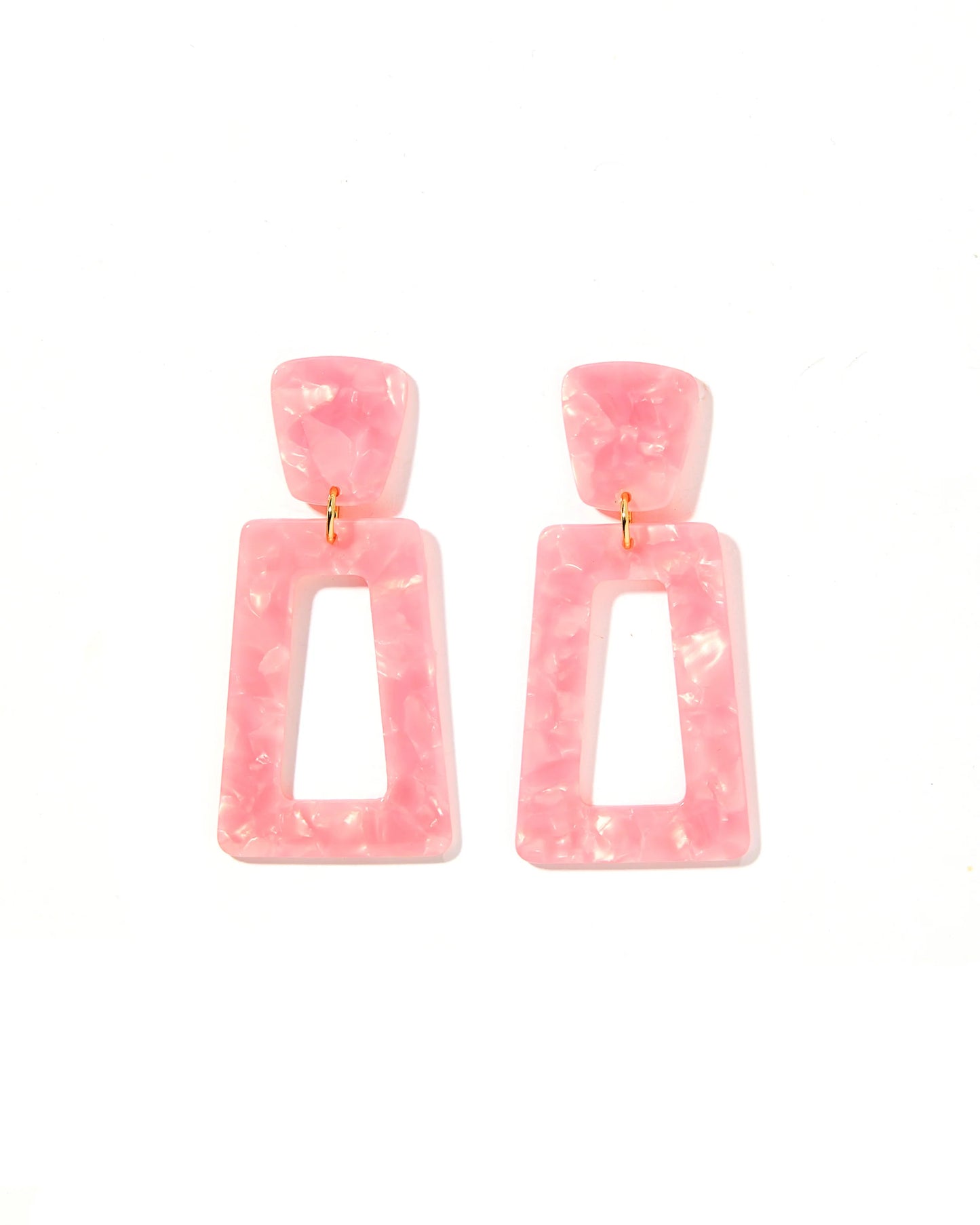 The Kennedy Earrings have a pink marbled resin geometric design with rounded square studs and open-centered rectangles. They are designed for sensitive ears and connected by small gold loops. Available in one size.