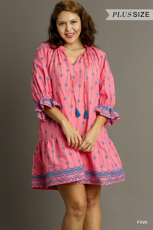 A-line dress features intricate embroidery, a split ruffle neckline, and tassel tie detail. Comes in a vibrant pink color. Available in various sizes.