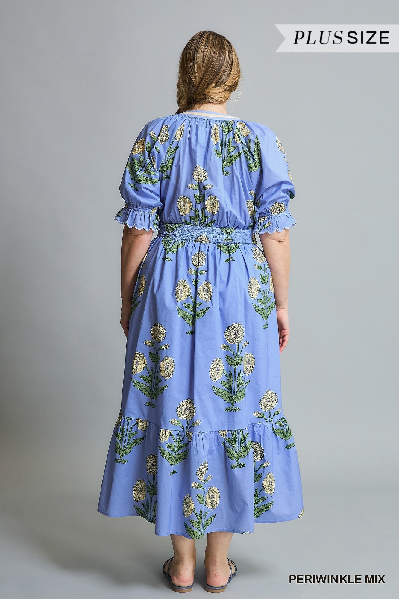 Avery Floral Smocked Midi Dress in Periwinkle Mix. Blue with green and white floral patterns. Ruffled sleeves, smocked bodice, mid-calf length. Available in plus sizes.