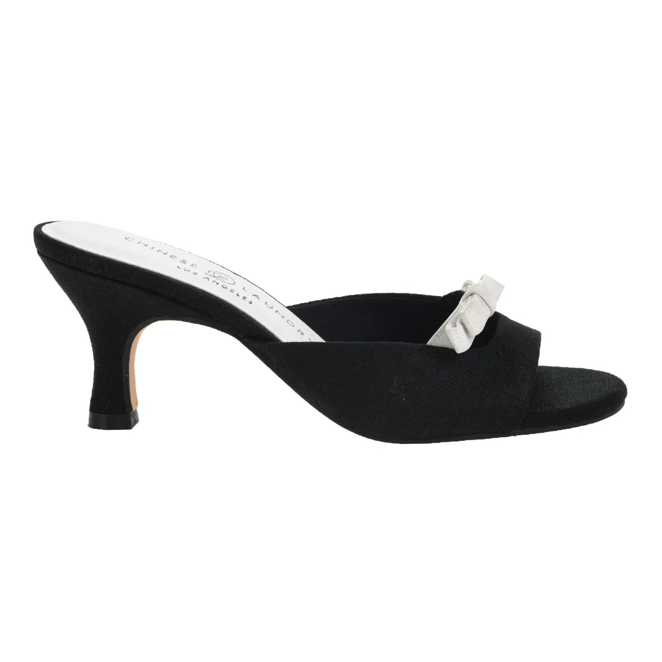 Meet the Yolana Heel - Black/White: a sleek slip-on high heel mule with an open toe, slender black heel, and a refined white bow on the strap. Sizes available: 5-11.