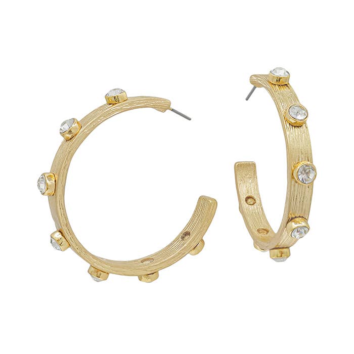 Gold hoop earrings with a textured finish and spaced clear round gemstones. Available in small, medium, and large sizes.
