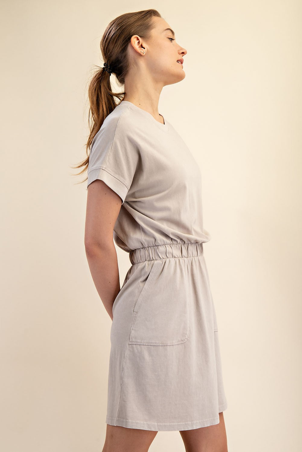 Mineral Washed Elastic Waist Cotton Dress in light gray. Mini-length, elastic waist, front pockets. Available in sizes XS–XL.