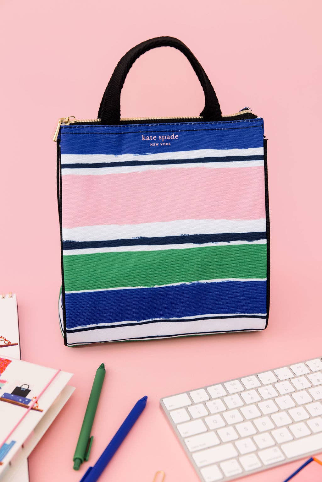 The Lunch Bag, Ocean Stripe has blue, pink, green, and white stripes. Available sizes: small, medium, large.