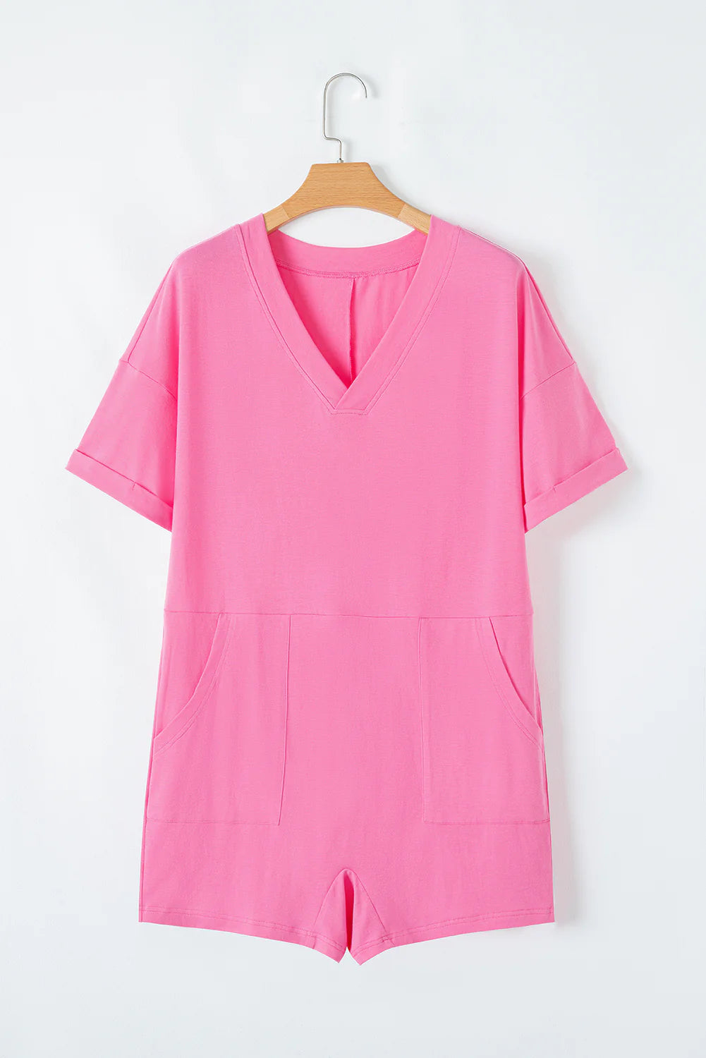 Pink loose half sleeve V neck knit romper with cuffed sleeves, two front pockets, and stretchy fabric. Available in sizes S, M, L.