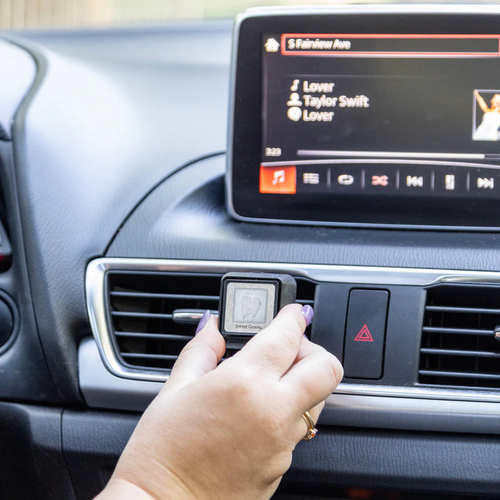 Auto Vent Clip Sweet Grace being clipped to a car vent; available in small and large sizes.