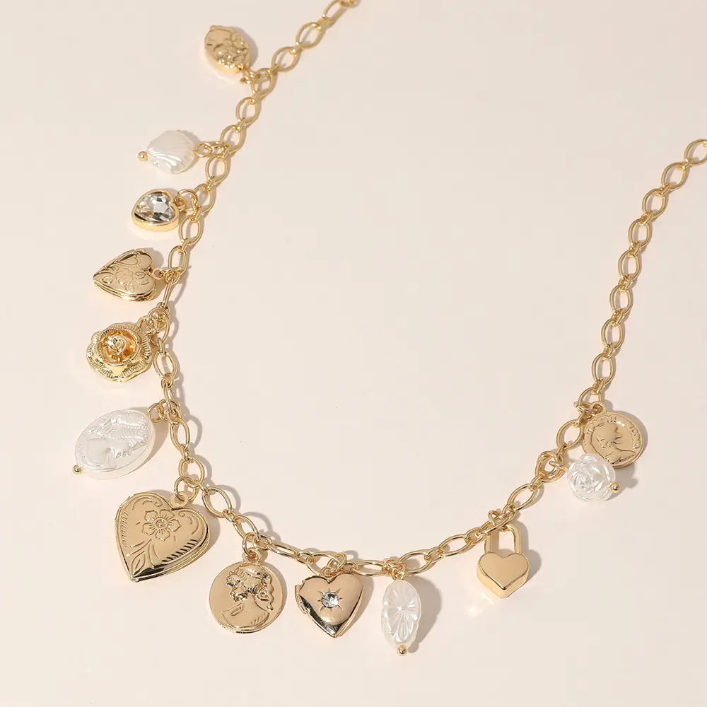 Metal Heart Locket Pearl Shell Charm Station Necklace: Gold chain with heart, circle, and teardrop gemstone pendants. Lead and nickel compliant. Available in one size.